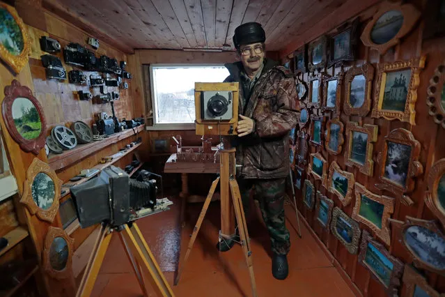 A local school teacher Pavel Kudryashov a large format photo camera found in a local photo atelier and exposed among other old cameras in his collection at his yard in a town of Soligalich, Kostroma region, some 600 km to North-East from Moscow, Russia, 10 January 2020. Pavel Kudryashov during many years has a hobby to design and to make bird feeders and bird houses, to collect different old things, found in the left unmanned villages around and to make his yard as a very attractive play ground for his grand children. Such a hobby brings interest in flat and boring province life. (Photo by Sergei Chirikov/EPA/EFE)