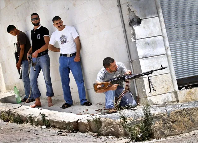 A Free Syrian Army fighter fires his weapon during clashes with Syrian troops near Idlib on June 15, 2012