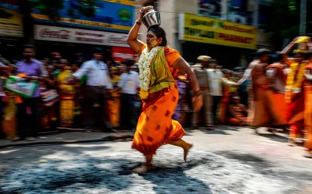 A Hindu devotee walks over burning coal during the Thaipoosam festival in Chennai on February 8, 2020. The festival is a purification ritual offering prayers and penance, observing a strict month long vegetarian diet and celebrating the birth of the eHindu deity Murugan. (Photo by Arun Sankar/AFP Photo)