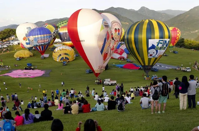 Spectators view hot air balloon during the 2016 International Hot Air Balloon Festival in Taitung, southeast of Taiwan, 01 July 2016. (Photo by Ritchie B. Tongo/EPA)