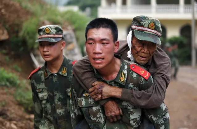 A paramilitary policeman carries an elderly man on his back after an earthquake hit Ludian county of Zhaotong, Yunnan province August 3, 2014. The magnitude 6.5 earthquake struck southwestern China on Sunday, killing at least 150 people in the remote mountainous area of Yunnan province, causing some buildings, including a school, to collapse, Xinhua News Agency reported. (Photo by Reuters/China Daily)