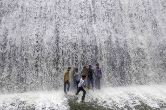 Boys play under an overflowing dam along the Powai lake after heavy rains in Mumbai, India, July 4, 2016. (Photo by Shailesh Andrade/Reuters)