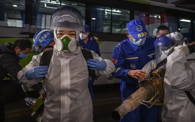Female Chinese volunteers from Blue Sky Rescue wear protective suits as they put on equipment before fumigating and disinfecting an area of a local bus station on March 7, 2020 in Beijing, China. The fumigation work, which is usually done by male volunteers, was done by a group of female volunteers in advance of International Women's Day. Blue Sky Rescue, which is China's largest non-profit rescue NGO, is said to have over 30,000 members and trained to assist in emergencies and natural disasters. The number of cases of the deadly new coronavirus COVID-19 being treated in China dropped to below 21,000 in mainland China Sunday, in what the World Health Organization (WHO) declared a global public health emergency last month. China continued to lock down the city of Wuhan, the epicentre of the virus, in an effort to contain the spread of the pneumonia-like disease. Officials in Beijing have put in place a mandatory 14 day quarantine for all people returning to the capital from other places in China and countries with a large number of cases like South Korea and Japan. The number of those who have died from the virus in China climbed to over 3100 on Sunday, mostly in Hubei province, and cases have been reported in other countries including the United States, Canada, Australia, Japan, South Korea, India, Iran, Italy, the United Kingdom, Germany, France and several others. The World Health Organization has warned all governments to be on alert and raised concerns over a possible pandemic. Some countries, including the United States, have put restrictions on Chinese travellers entering and advised their citizens against travel to China. (Photo by Kevin Frayer/Getty Images)
