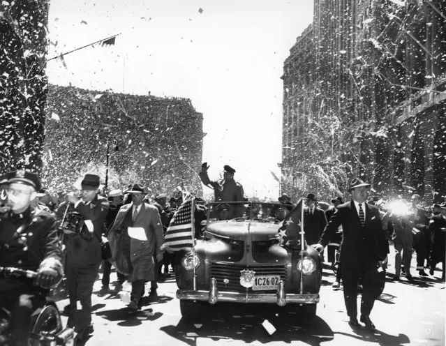 In this April 20, 1951 file photo, Gen. Douglas MacArthur waves from an open car during the ticker-tape parade in his honor in New York's financial district on lower Broadway.. (Photo by AP Photo)