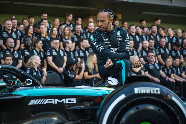 Mercedes' British driver Lewis Hamilton sits on his car as he arrives to pose for a group photo with his team ahead of the Abu Dhabi Formula One Grand Prix at the Yas Marina Circuit in Abu Dhabi on December 5, 2024. (Photo by Andrej Isakovic/AFP Photo)