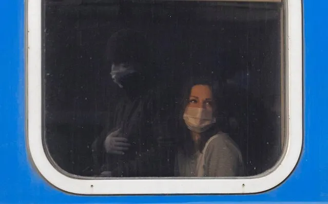 A Ukrainian woman wearing a face mask as a preventive measure on a train with Ukrainians evacuated from Moscow at at Kiev railway station on March 29, 2020. Due to the situation with the novel coronavirus (COVID-19), a special train will be launched on the route Kiev – Moscow – Kiev to evacuate Russians from Ukraine and Ukrainians from the Russian Federation ahead of Ukrainian and Russian borders closing. (Photo by Pavlo Gonchar/SOPA Images)