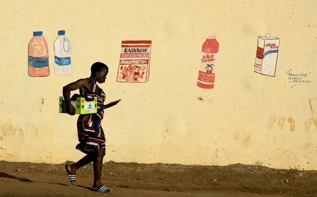 A woman counts her change as she leaves a convenience store, or “spaza shop”, with a mural depicting grocery items, during a nationwide lockdown for 21 days to try to contain the coronavirus disease (COVID-19) outbreak, at the Elias Motsoaledi informal settlement, South Africa, April 7, 2020. (Photo by Siphiwe Sibeko/Reuters)