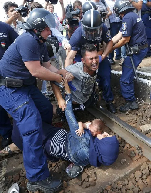 Hungarian policemen detain migrants on the tracks as they wanted to run away at the railway station in the town of Bicske, Hungary, September 3, 2015. (Photo by Laszlo Balogh/Reuters)