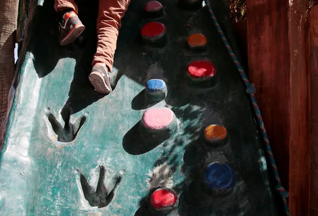 A child walks up a playground climber with dinosaur footprints at the Cretaceous park in Cal Orcko, on the outskirts of Sucre, Bolivia, July 22, 2016. (Photo by David Mercado/Reuters)