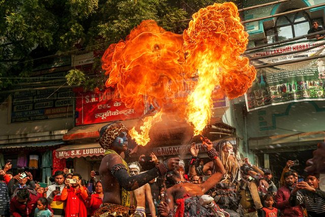 Hindu devotees perform fire-breathing act during a religious procession ahead of the Maha Kumbh Mela festival in Prayagraj on January 10, 2025. (Photo by Niharika Kulkarni/AFP Photo)