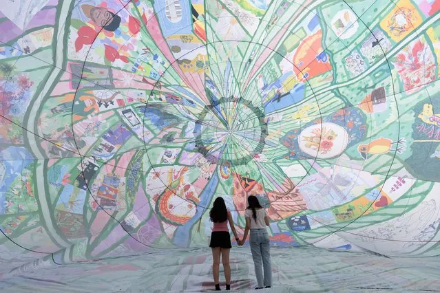 Twins Gonul Ali and Goode Ali attend the inaugural flight of major new artwork “Fields of EveryWhen”, a spectacular 25 meter high hot air balloon celebrating the people and places of Thamesmead, by artists musson+retallick, winners of the Thamesmead Open, an international art competition, organised by Peabody at Southmere Square on August 15, 2022 in London, England. The 25 metre high  hot air balloon features over 200 artworks celebrating Thamesmead creating a spectacular exhibition in the sky.  The balloon will fly 5 times over Thamesmead this summer including at the Thamesmead Festival on Saturday 20th of August. (Photo by John Phillips/Getty Images for Peabody)