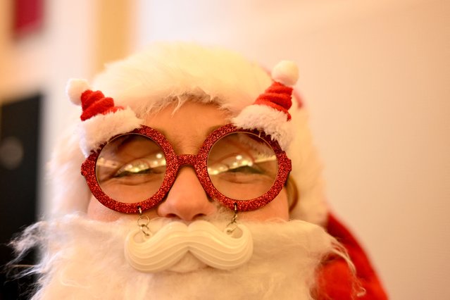 An athlete wearing a fancy Santa Claus costume gets ready to take part in the “Michendorfer Nikolauslauf” fun run on December 8, 2024 in Michendorf, south of Berlin, eastern Germany. (Photo by Ralf Hirschberger/AFP Photo)