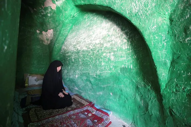 A woman prays inside the shrine of Imam Mahdi at the Wadi al-Salam cemetery, Arabic for “Peace Valley”, in Najaf, south of Baghdad, Iraq, August 1, 2016. (Photo by Alaa Al-Marjani/Reuters)