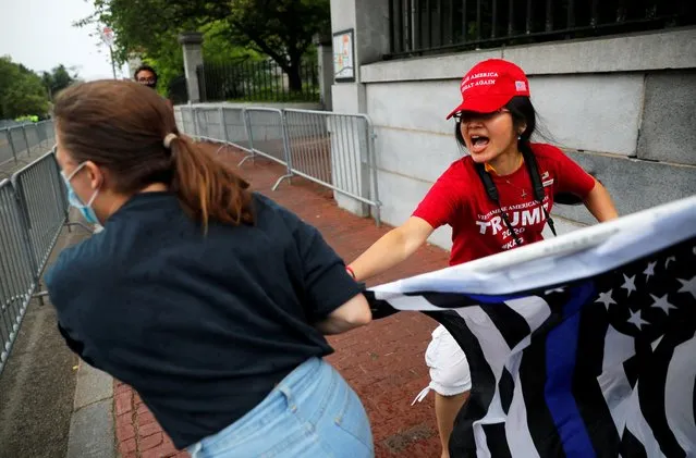 A counter-protester grabs the flag of a pro-police demonstrator during a rally, following weeks of protests against racial inequality in the aftermath of the death in Minneapolis police custody of George Floyd, in Boston, Massachusetts, U.S. June 27, 2020. (Photo by Brian Snyder/Reuters)