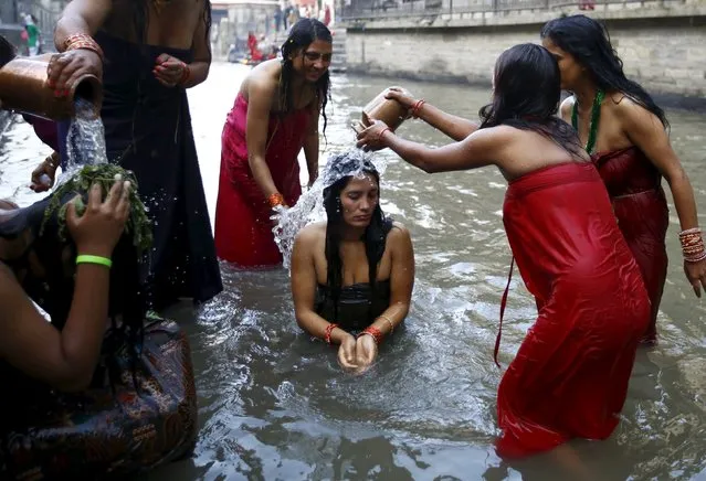 Nepalese women performs ritual as they take a holy bath in the Bagmati River, during the Rishi Panchami festival, in Kathmandu, Nepal September 18, 2015. Rishi Panchami is observed on the last day of Teej when women worship Sapta Rishi (Seven Saints) to ask for forgiveness for sins committed during their menstrual periods throughout the year. (Photo by Navesh Chitrakar/Reuters)