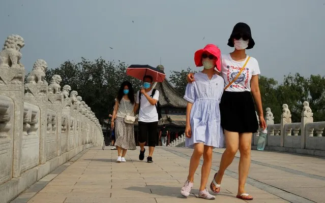 People wearing protective masks walk in the park at Summer Palace on a public holiday, after a new outbreak of the coronavirus disease (COVID-19), in Beijing, China, June 26, 2020. (Photo by Thomas Peter/Reuters)
