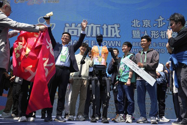 The team behind the Sky Project Ultra robot also known as Tien Kung Ultra celebrate after winning the Humanoid Robot Half-Marathon held in Beijing on Saturday, April 19, 2025. (Photo by Ng Han Guan/AP Photo)
