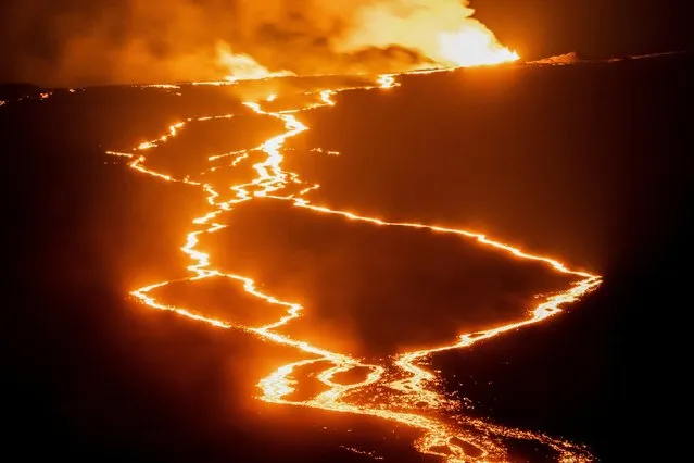 Lava fountains and flows illuminate the area during the Mauna Loa volcano eruption in Hawaii, U.S. November 30, 2022. (Photo by Go Nakamura/Reuters)