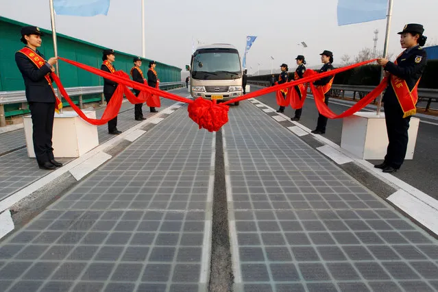 A vehicle is seen on a solar panel expressway during its opening in Jinan, Shandong province, China December 28, 2017. World's first photovoltaic road has been finished construction and put into test run on Thursday in Jinan. The 2-kilometer-long photovoltaic road is built 1 kilometer east to the Jinan south toll station, and the electric it generates will be delivered to the nearby small power stations. The road with transparent concrete on top can bear the weight of small vehicles and medium trucks. (Photo by Reuters/China Stringer Network)