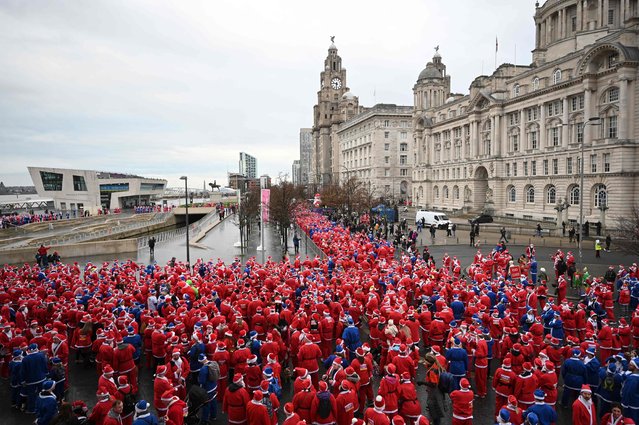 Runners dressed in Father Christmas attire prepare to take part in the annual five-kilometre Santa Dash in Liverpool, northwest England, on December 4, 2022. Many runners opt to wear a blue suit, typically supporters of Everton Football Club, rather than a red one, as red is the colour of their bitter rivals Liverpool Football Club. The Liverpool Santa Dash is the biggest and longest established Santa Run in the UK, with approximately 5500 runners taking part. (Photo by Oli Scarff/AFP Photo)
