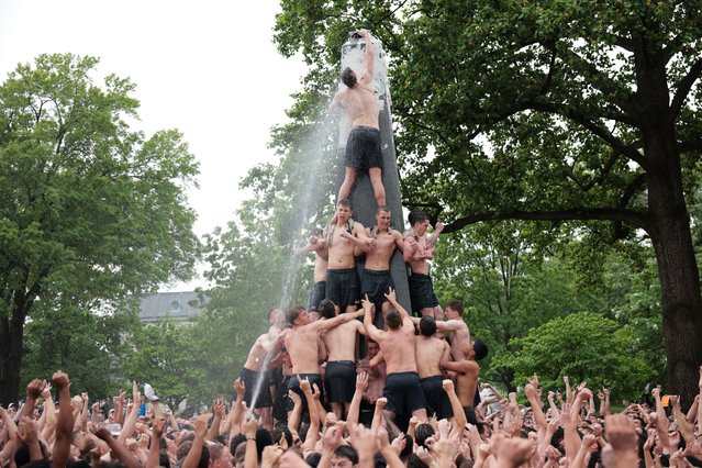 U.S. Naval Academy freshman (“plebes”) are sprayed with water as they place the hat during the annual Herndon Monument climb at the U.S. Naval Academy on May 14, 2025 in Annapolis, Maryland. In the annual tradition, the plebes attempt to scale the 21-foot greased monument to knock off a “dixie cup” hat and replace it with an upperclassman’s hat. The 2028 midshipmen's class took 2 hours 27 minutes and 31 seconds to scale the monument and replace the hat. (Photo by Kayla Bartkowski/Getty Images)