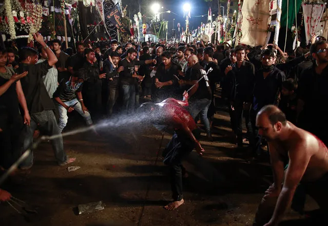 A Shi'ite Muslims is sprayed with rose water as he flagellates himself during a Muharram procession ahead of Ashura in Mumbai November 3, 2014. (Photo by Danish Siddiqui/Reuters)