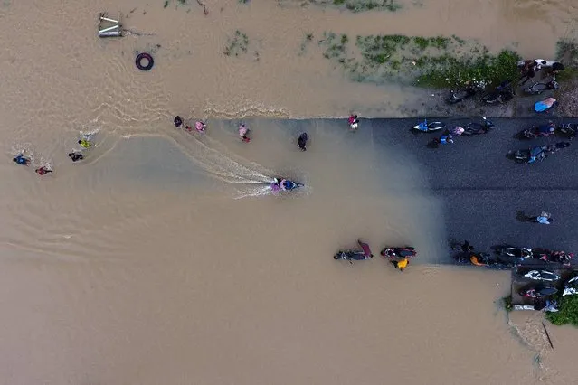 This aerial photo taken on December 21, 2022 shows motorists traveling in a flooded area in Matangkuli. (Photo by Zikri Maulana/AFP Photo)