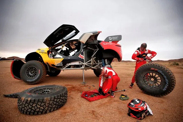Bahrain Raid Xtreme's Sebastien Loeb and co-driver Fabian Lurquin are pictured making repairs on their car during Stage 3, Alula to Ha'il in Saudi Arabia on January 3, 2023. (Photo by Hamad I Mohammed/Reuters)