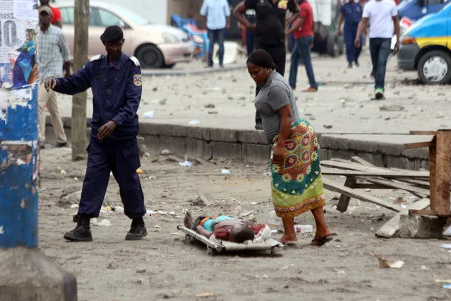 A woman looks at the body of a man killed during election protests in Kinshasa, Democratic Republic of Congo, Monday, September 19, 2016. (Photo by John Bompengo/AP Photo)