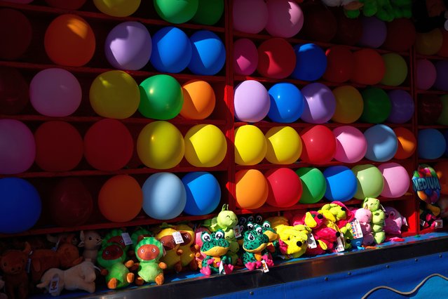 Stuffed animal prizes are displayed below a balloon game at the Ventura County Fair in Ventura, California, USA, 5 August 2025. The fair is an annual event held each August in Ventura, California, at Seaside Park, and includes an agricultural show, carnival rides, food booths, and nightly concerts. (Photo by Allison Dinner/EPA)