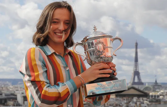 The Eiffel Tower is seen in the background, as Poland's Iga Swiatek, suddenly becoming a Grand Slam champion at the age of 19, poses with her trophy during a photo call on the rooftop of Galeries Lafayette, Sunday, October 11, 2020, after winning the final match of the French Open tennis tournament at the Roland Garros stadium in Paris, France, Saturday. (Photo by Christophe Ena/AP Photo)