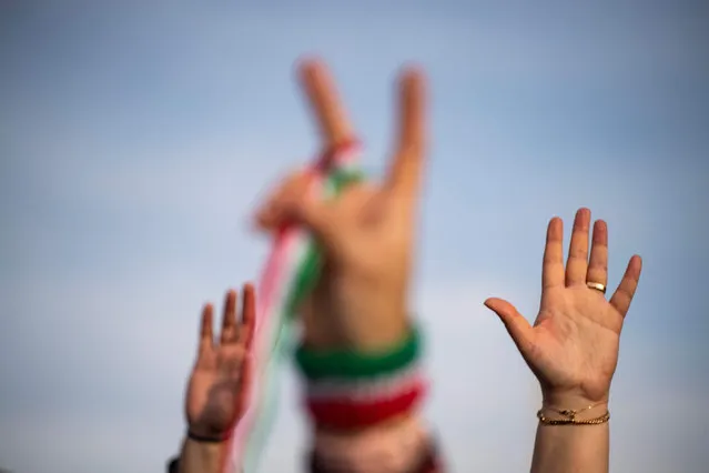 People raise their hands during a demonstration to denounce the Iranian government and express support with anti-government protesters in Iran, at the Lincoln Memorial in Washington, DC, on February 11, 2023. The demonstrations coincides with the 44th anniversary of the Islamic Revolution. (Photo by Roberto Schmidt/AFP Photo)
