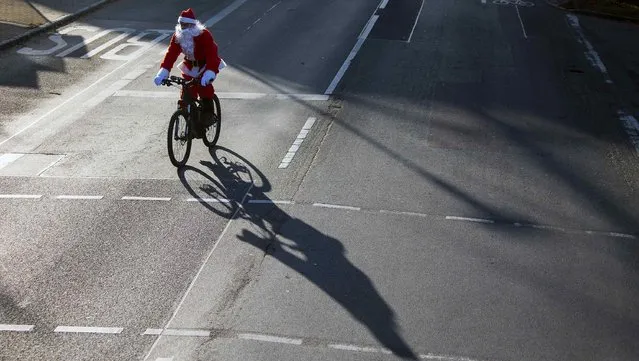 A man dressed as Father Christmas rides a bicycle during the Nikolaus Lauf (Santa Claus Run) in the east German town of Michendorf, southwest of Berlin December 7, 2014. (Photo by Hannibal Hanschke/Reuters)