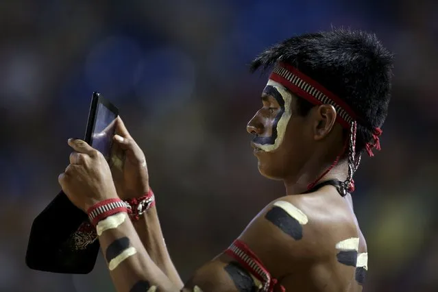 An indigenous man from the Bororo tribe take a picture during the closing ceremony of the first World Games for Indigenous Peoples in Palmas, Brazil, October 31, 2015. (Photo by Ueslei Marcelino/Reuters)