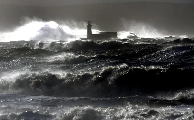 Giant waves batter the lighthouse wall at Whitehaven, a port on the coast of Cumbia, north west England December 10, 2014 as the stormy weather is causing disruption across parts of the UK with power cuts, ferry and train cancellations and difficult driving conditions. The country is experiencing explosive cyclogenesis known as a “weather bomb” and widespread flooding is anticipated in Scotland and bordering areas of England.  (Photo by Owen Humphreys/EPA)
