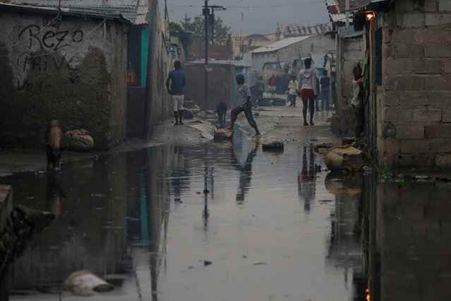 People walk on a flooded street after Hurricane Matthew passes Cite-Soleil in Port-au-Prince, Haiti, October 5, 2016. (Photo by Carlos Garcia Rawlins/Reuters)