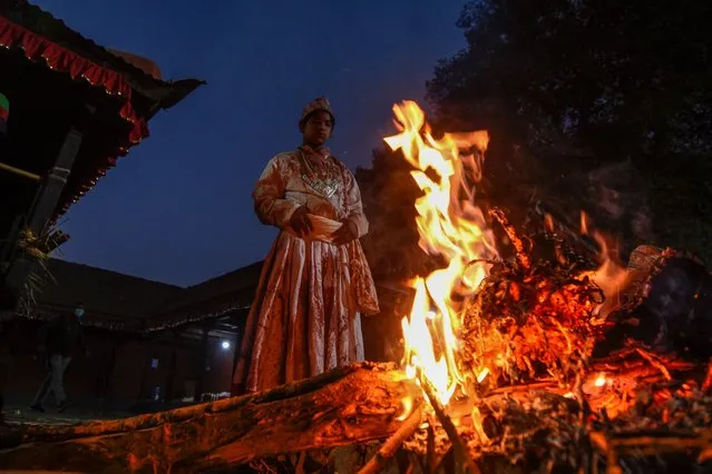 A Hindu priest stands in front of a fire at the Baramahini Temple during the tenth day of Dashain festival in Bhaktapur, on the outskirts of Kathmandu, on October 26, 2020. (Photo by Prakash Mathema/AFP Photo)