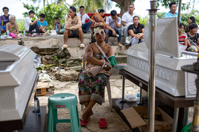Jesiel Malinao, 34, who survived the magnitude 6.9 quake, sits between the coffins of her two children during their wake in Bogo, Cebu, Philippines, on October 2, 2025. (Photo by Eloisa Lopez/Reuters)