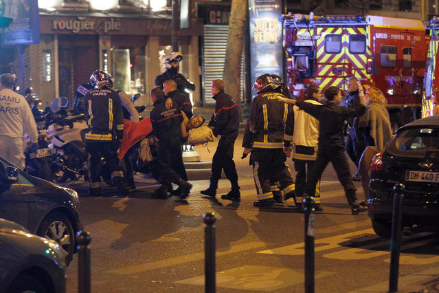Medics move a wounded man near the Boulevard des Filles-du-Calvaire after an attack November 13, 2013 in Paris, France. Gunfire and explosions in multiple locations erupted in the French capital with early casualty reports indicating at least 60 dead. (Photo by Thierry Chesnot/Getty Images)