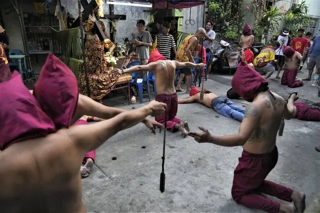 Hooded Filipino flagellants pray as part of Maundy Thursday rituals to atone for sins or fulfill vows for an answered prayer on April 6, 2023 at Mandaluyong city, Philippines. COVID restrictions the past years have prevented crowds and devotees in participating in bizarre lenten rituals, a practice which have been opposed by the church in this predominantly Roman Catholic country. (Photo by Aaron Favila/AP Photo)
