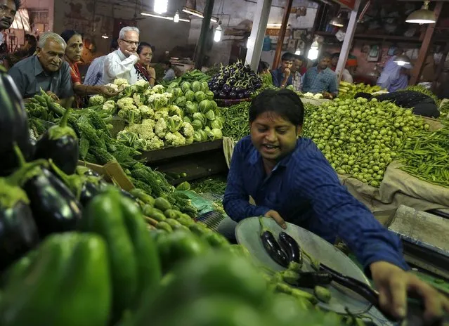 Customers (L) buy vegetables at a market in Ahmedabad, India, November 9, 2015. India's villages face a sharp spike in food prices in 2016, as a second year of drought drives up the cost of ingredients such as sugar and milk, and poor transport infrastructure stops falling global prices from reaching rural areas. (Photo by Amit Dave/Reuters)