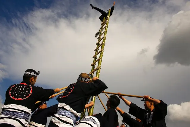 A member of the Edo Firemanship Preservation Association displays his balancing skills atop bamboo ladder during a New Year presentation by the fire brigade in Tokyo January 6, 2015. (Photo by Thomas Peter/Reuters)