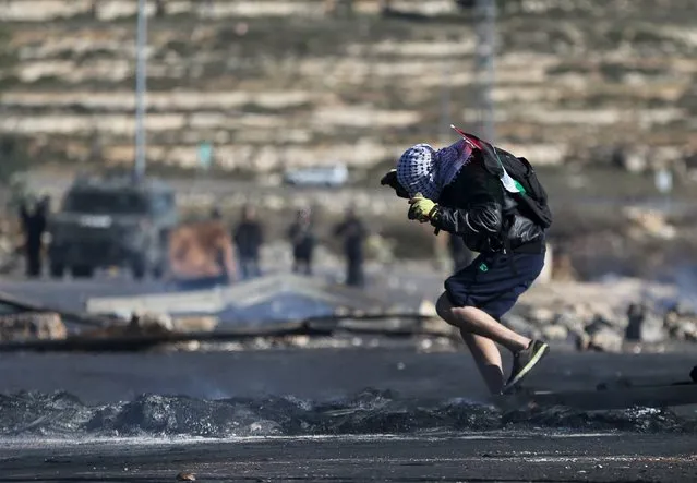 A Palestinian protester runs for cover during clashes with Israeli troops near the Jewish settlement of Bet El, near the West Bank city of Ramallah November 24, 2015. (Photo by Mohamad Torokman/Reuters)