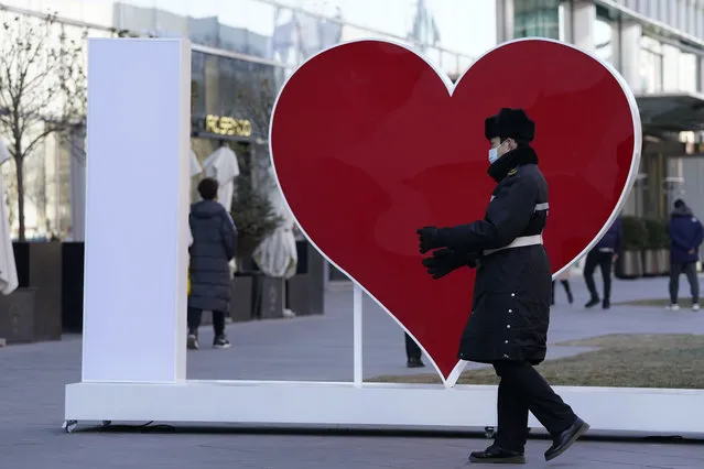 A security guard wearing a mask to protect from the coronavirus walks a heart shape in Beijing on Monday, January 4, 2021. Wary of another wave of infections, China is urging tens of millions of migrant workers to stay put during next month's Lunar New Year holiday, usually the world's largest annual human migration. (Photo by Ng Han Guan/AP Photo)