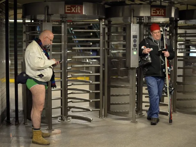 A participant in the No Pants Subway Ride waits for a train in New York subway on January 11, 2015 in New York. (Photo by Timothy A. Clary/AFP Photo)