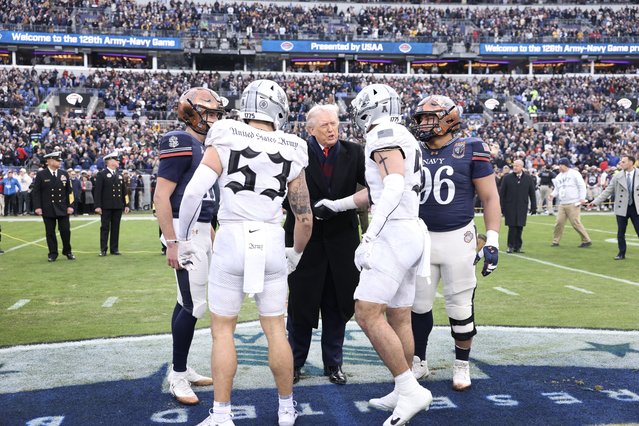 President Donald Trump (C) greets players after the coin toss and before the start of the 126th Army-Navy Game between the Army Black Knights and the Navy Midshipmen at M&T Bank Stadium on December 13, 2025 in Baltimore, Maryland. The teams are competing for the Commander-in-Chief's Trophy, with President Trump attending the rivalry for the second consecutive year. (Photo by Tasos Katopodis/Getty Images/AFP Photo)