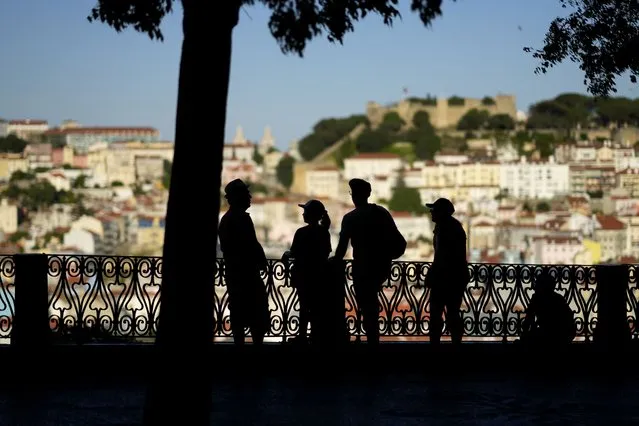 People stop to look at the view from a public garden in Lisbon's Bairro Alto, or High Quarter, April 17, 2023. Record-breaking April temperatures in Spain, Portugal and northern Africa were made 100 times more likely by human-caused climate change, a new flash study found. (Photo by Armando Franca/AP Photo)