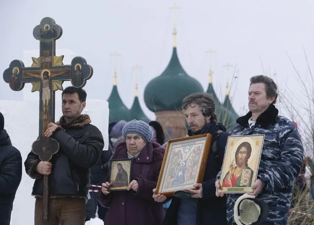 People attend an Orthodox religious service during a water blessing ceremony on Epiphany Day in the village of Velikoye, Yaroslavl region, January 18, 2015. (Photo by Sergei Karpukhin/Reuters)