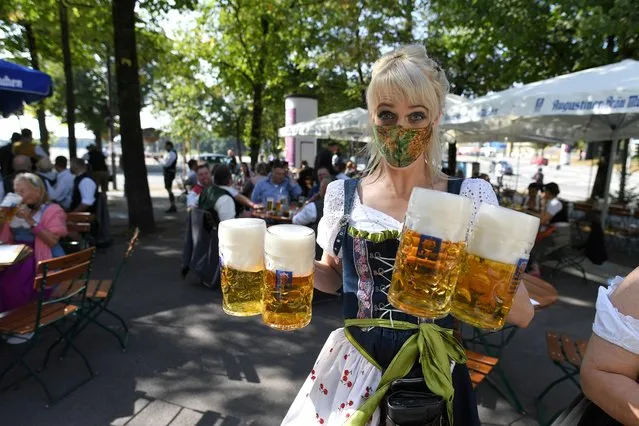 A server carries mugs during a barrel tapping at a beer garden near Theresienwiese where Oktoberfest would have started today as COVID-19 continues in Munich, Germany, September 19, 2020. (Photo by Andreas Gebert/Reuters)