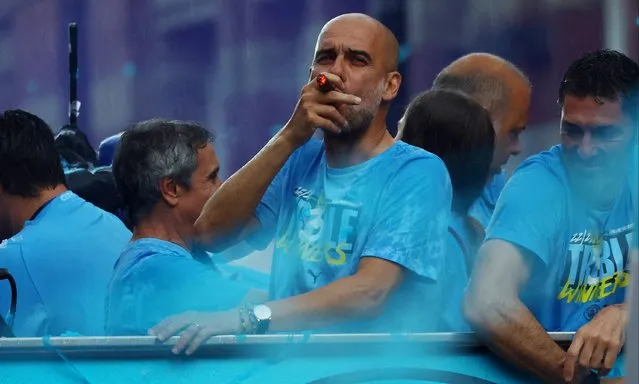 Pep Guardiola, Manager of Manchester City, smoked a cigar on the Open-Top Bus during the Manchester City trophy parade on June 12, 2023 in Manchester, England. (Photo by Molly Darlington/Reuters)
